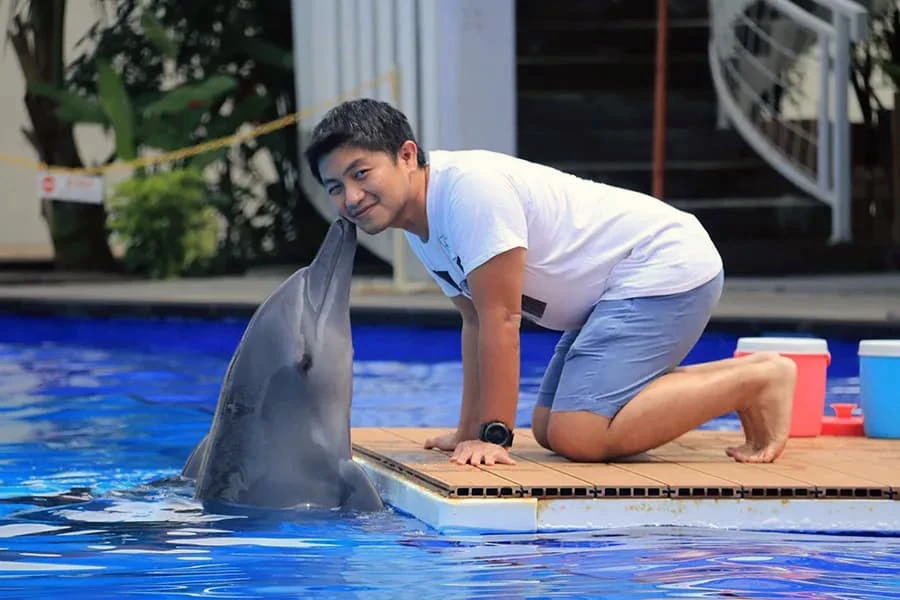 man kissed by dolphin